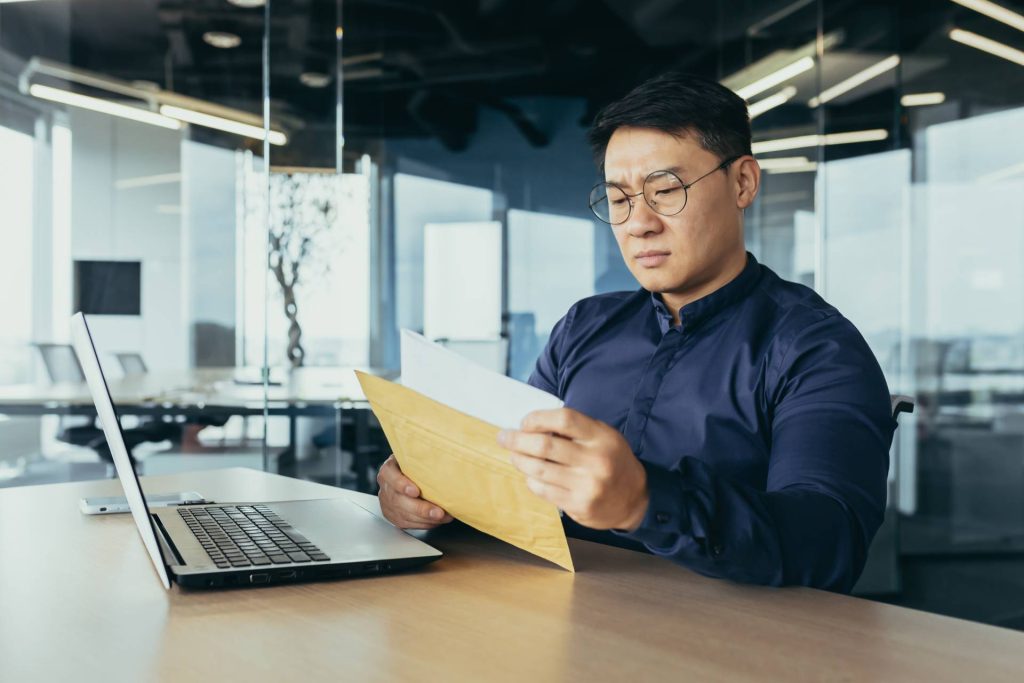 Serious and upset businessman reading letter